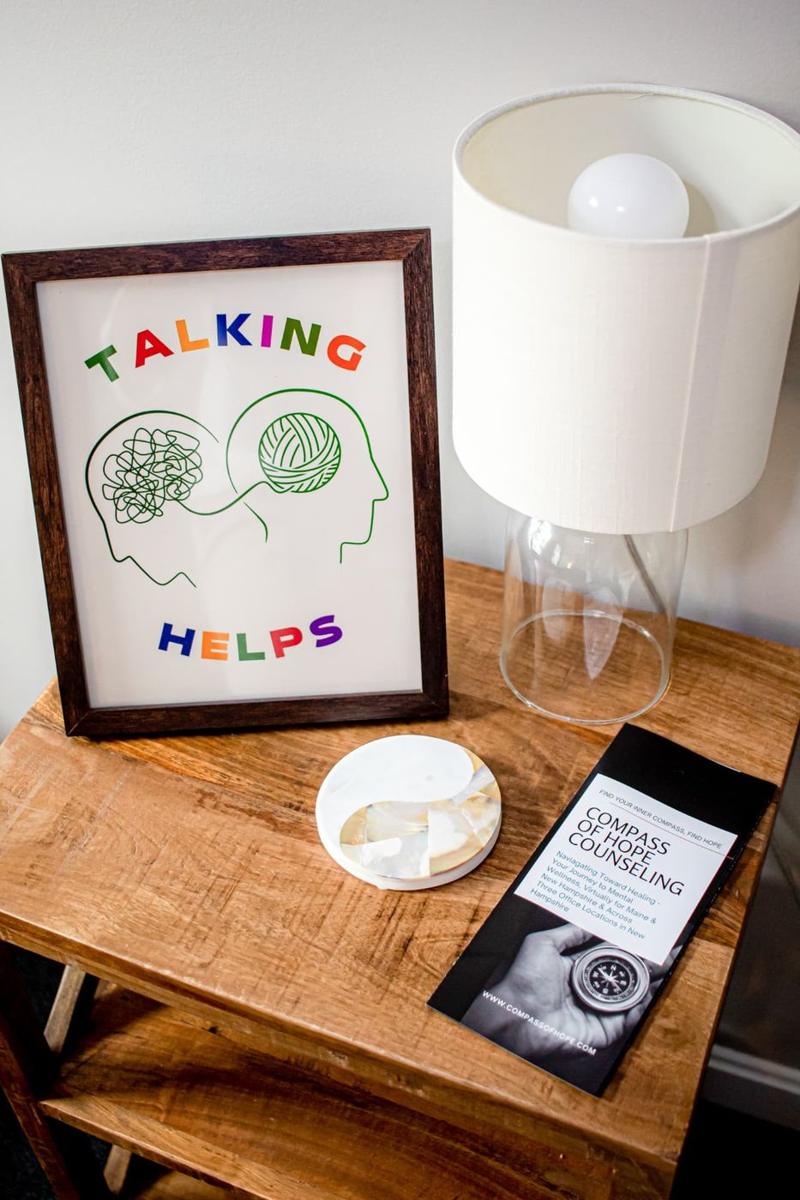 A framed “Talking Helps” print and a Compass of Hope brochure on a side table
